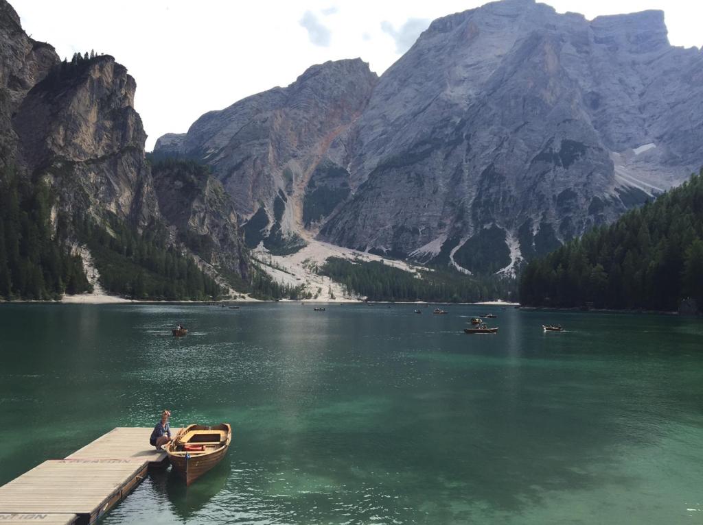 Photo of a lake with few people and the mountains in the background
